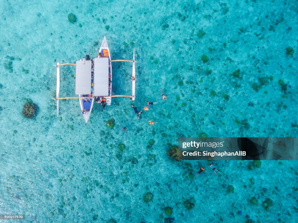 Aerial view from top of traditional boat Bora bora and diving tourists