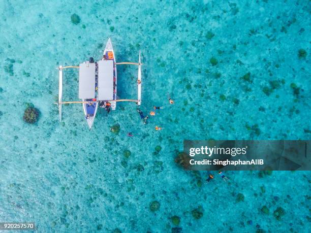 aerial view from top of traditional boat bora bora and diving tourists - bora bora foto e immagini stock