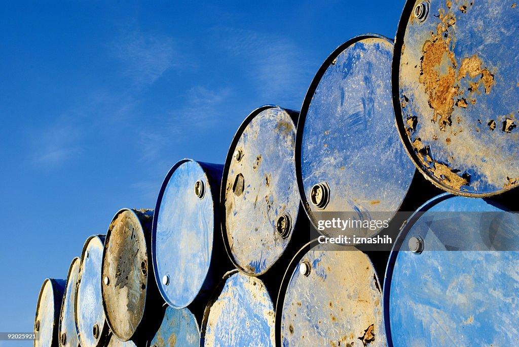 Rusty metal barrels stacked in rows