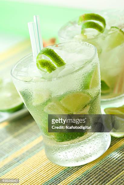 glass of caipirinha cocktail on green table - caipirinha stock pictures, royalty-free photos & images