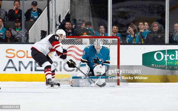 Martin Jones of the San Jose Sharks defends the net against Christian Dvorak of the Arizona Coyotes at SAP Center on February 13, 2018 in San Jose,...