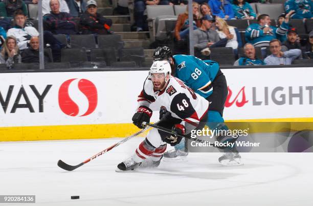 Jordan Martinook of the Arizona Coyotes skates after the puck against Brent Burns of the San Jose Sharks at SAP Center on February 13, 2018 in San...