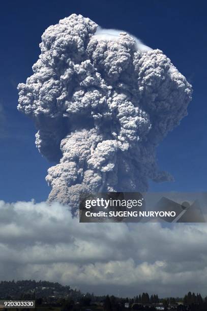 Plume of think volcanic ash hangs in the air from Mount Sinabung volcano, taken from the city of Berastagi in North Sumatra on February 19, 2018....