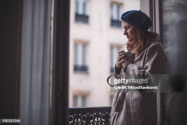 femme de boire du café sur le balcon - paris hiver photos et images de collection