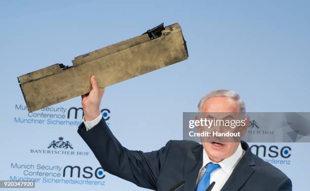 In this handout photo Israeli Prime Minister Benjamin Netanyahu holds up what he claims is a piece of an Iranian drone that was shot down after it...