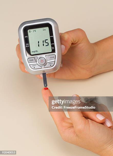 portable blood glucose testing meter with female hands - glycemia stock pictures, royalty-free photos & images