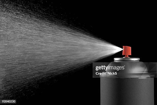 spraying aerosol can against black background - aerosol can stock pictures, royalty-free photos & images