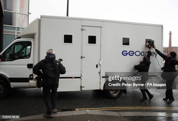 Photographers take pictures through the window of a GEOAmey van arriving at Liverpool Crown Court ahead of the appearance of serial paedophile...