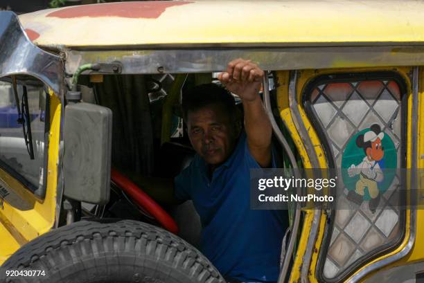 Jeepney driver raises his fist to express his support for jeepney drivers belonging to the activist jeepney driver group PISTON holding a protest...