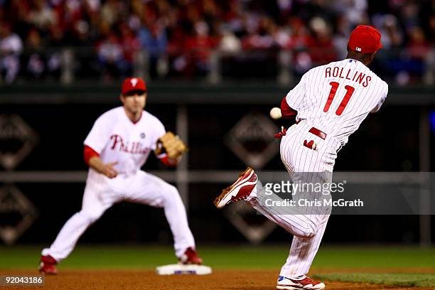 Jimmy Rollins of the Philadelphia Phillies flips the ball to Chase Utley to force out James Loney of the Los Angeles Dodgers on a fielder's choice...