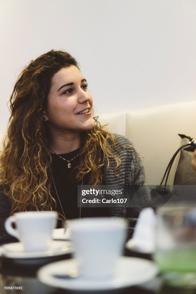 Giovane donna sorridente durante una pausa caffè