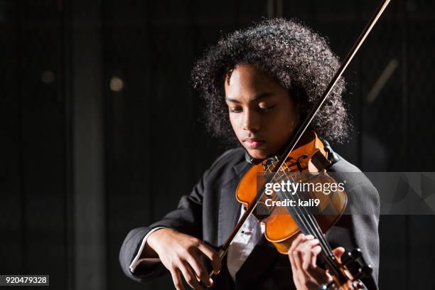 adolescente de raza mixta tocando el violín - violin fotografías e imágenes de stock