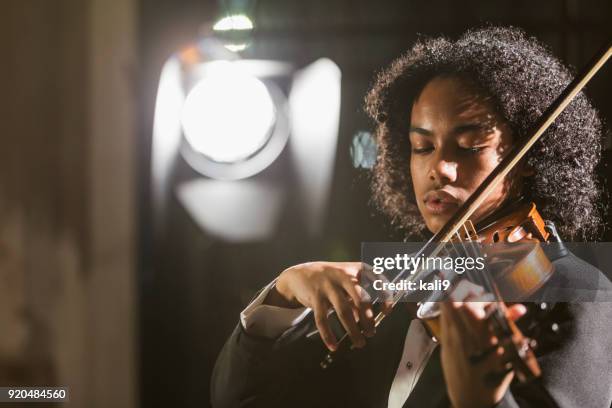 mixed race teenage boy playing the violin - student on stage stock pictures, royalty-free photos & images