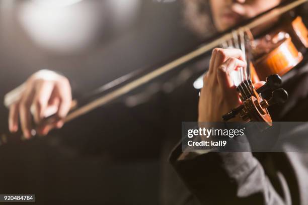 mixed race teenage boy playing the violin - symphony orchestra stock pictures, royalty-free photos & images