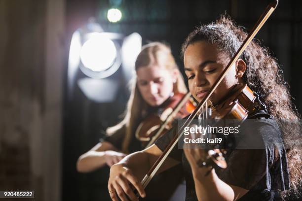 teenage girls playing violin in concert - performance stock pictures, royalty-free photos & images