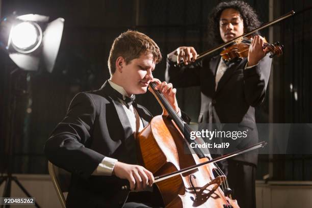 tienerjongens contrabas en viool spelen in concert - symphony orchestra stockfoto's en -beelden