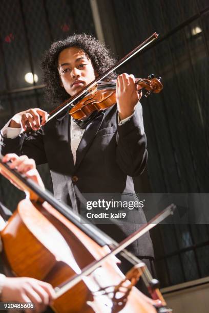 adolescente di razza mista che suona il violino - orchestra foto e immagini stock