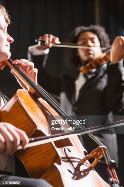 teenager jungs spielen kontrabass und violine in konzert - klassisches konzert stock-fotos und bilder