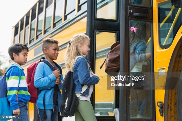 Multi-étnica crianças embarcando um ônibus escolar