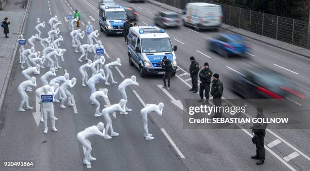 Greenpeace activists wear white morphsuits as they stage an action against particulate matter and health burden caused by diesel exhaust on February...