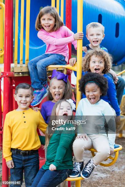 multiethniques écoliers sur l’aire de jeux - preschool age photos et images de collection