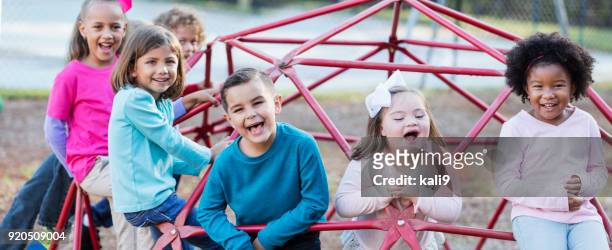 children playing on playground monkey bars - special needs children stock pictures, royalty-free photos & images