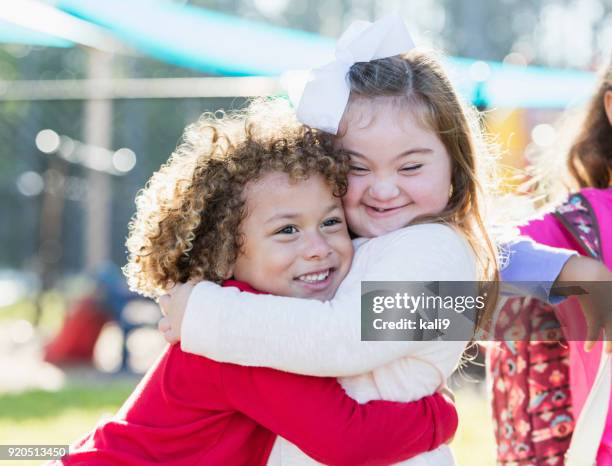 meisje met syndroom van down en jongen knuffelen - down syndrome care stockfoto's en -beelden