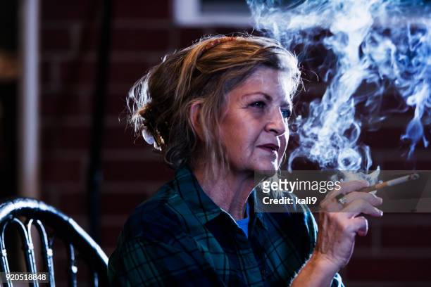 senior woman smoking a cigarette - smoking issues stock pictures, royalty-free photos & images