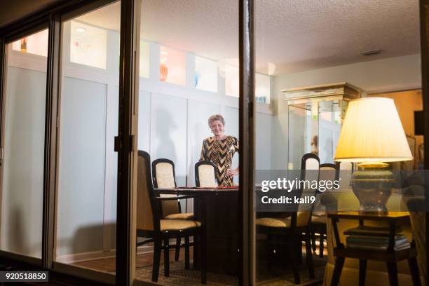 senior woman preparing to host dinner party - on the outside looking in stock pictures, royalty-free photos & images