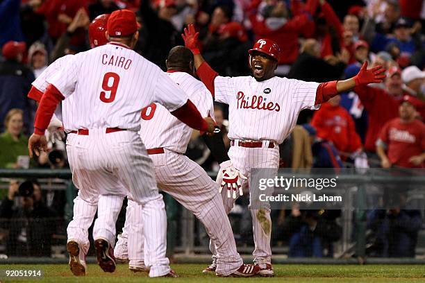 Jimmy Rollins of the Philadelphia Phillies celebrates with teammates after Rollins hit a game-winning 2-run double in the bottom of the ninth inning...
