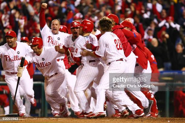 Carlos Ruiz of the Philadelphia Phillies celebrates with his teammates after he scored the winning run on a walkoff 2-run double by Jimmy Rollins...