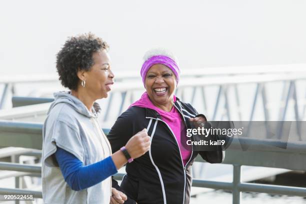 two mature women jogging or power walking together - two women running stock pictures, royalty-free photos & images