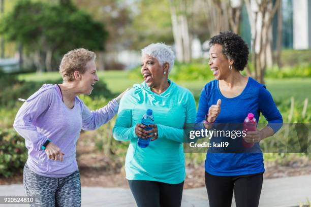 drie rijpe vrouwen oefenen in park, wandelen, praten - chatting park stockfoto's en -beelden