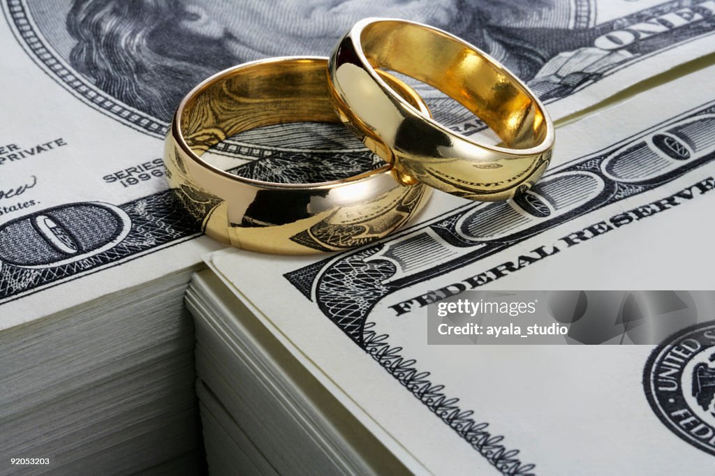 Alianças de casamento e pilha de dinheiro