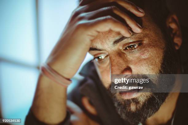 sad mid adult man thinking at home. - upset man imagens e fotografias de stock