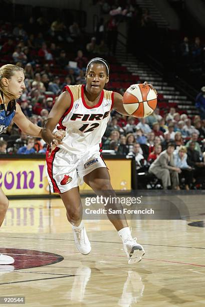 Carolyn Young of the Portland Fire drives to the basket defended by Helen Luz during the game on June 28, 2002 at the Rose Garden in Portland,...