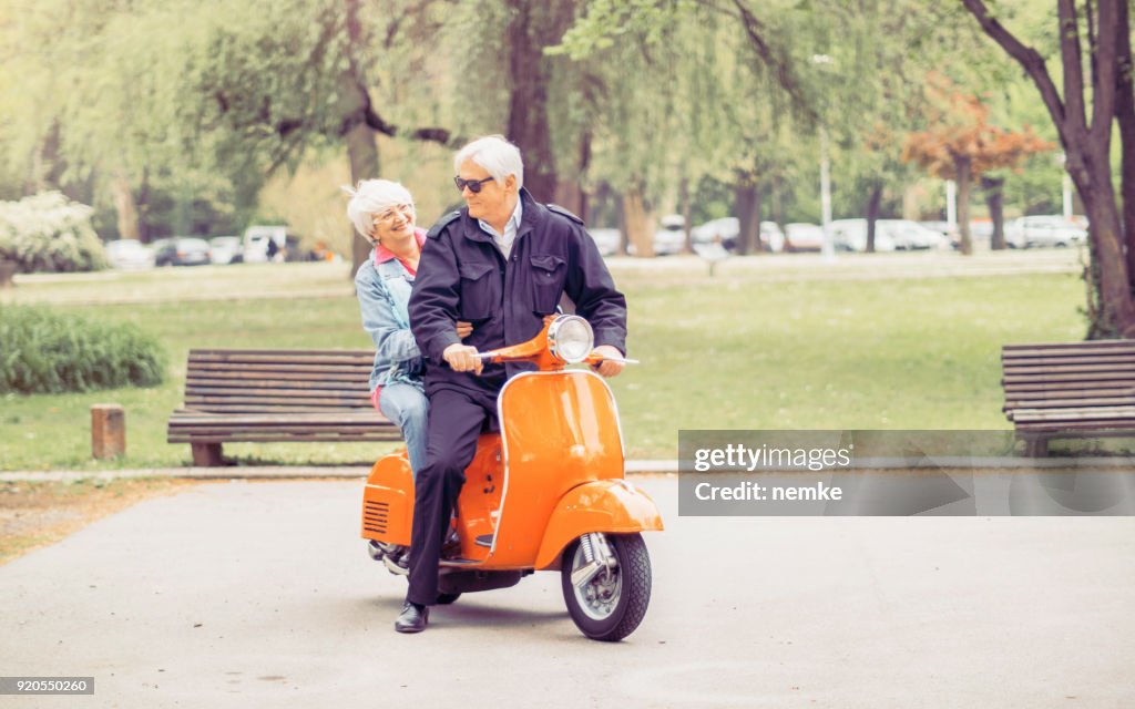 Femme Mature senior et homme au volant d’une moto