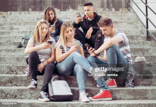 personas obsesionan con sus teléfonos inteligentes - mirar fijamente fotografías e imágenes de stock