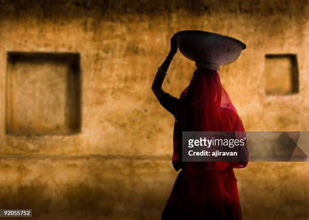 a picture of an indian woman in a red dress - rural scene stock pictures, royalty-free photos & images