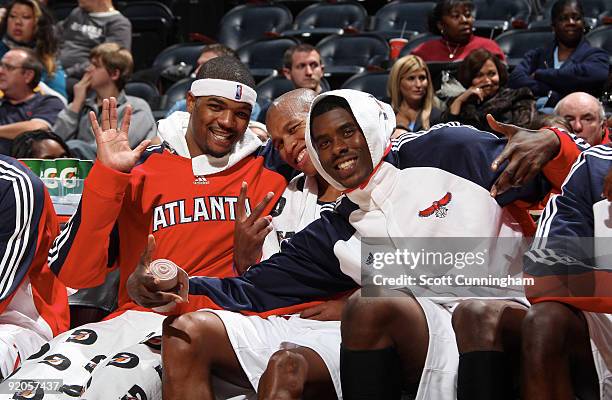 Josh Smith, Maurice Evans and Marvin Williams of the Atlanta Hawks relax on the bench during a preseason game against the Washington Wizards on...