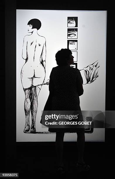 Woman looks on September 24, 2009 at an original comic strip sketch at the "Sexties" exhibition at the Beaux Arts Palace in Brussels, focusing on...