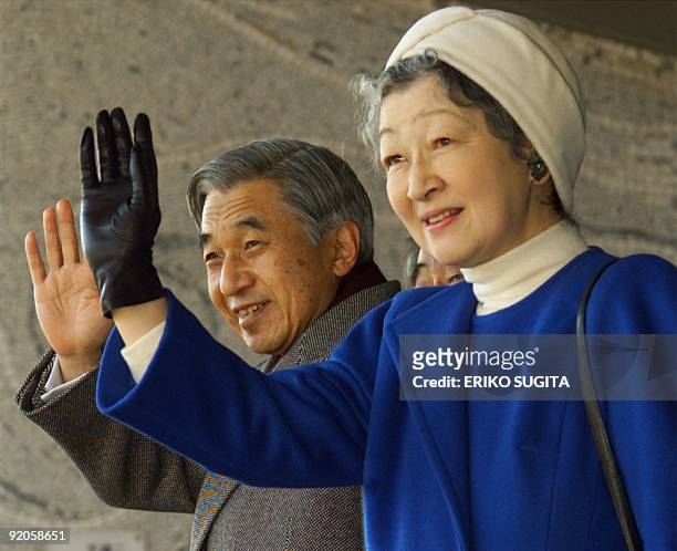 Emperor Akihito and Empress Michiko of Japan wave to soccer fans as they arrive at Tokyo's National Stadium to watch the Emperor's Cup soccer...