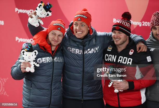 Joint gold medalists Francesco Friedrich and Thorsten Margis of Germany and Justin Kripps of Canada celebrate during the victory ceremony after the...