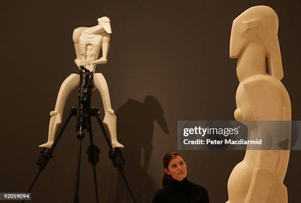 An employee looks at Jacob Epstein's 'Venus - second version' with his 'Rock Drill' behind at the Royal Academy of Arts on October 20, 2009 in...