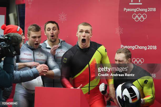 Francesco Friedrich and Thorsten Margis of Germany react as they watch the final run by Justin Kripps and Alexander Kopacz of Canada during the Men's...