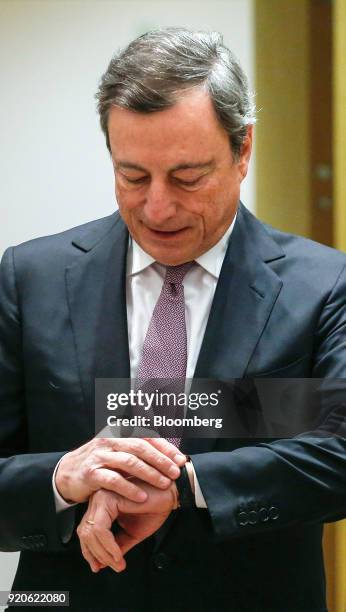 Mario Draghi, president of the European Central Bank , looks at his wristwatch as he arrives for a Eurogroup finance ministers meeting in Brussels,...