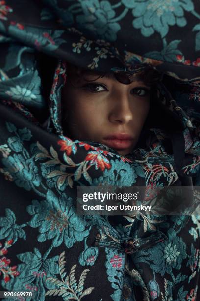 face of young woman surrounded by blue flowers - haute couture stock pictures, royalty-free photos & images