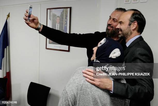 French Prime Minister Edouard Philippe poses for a 'selfie' with refugees who signed "Republican Integration Contracts" during a visit to a...