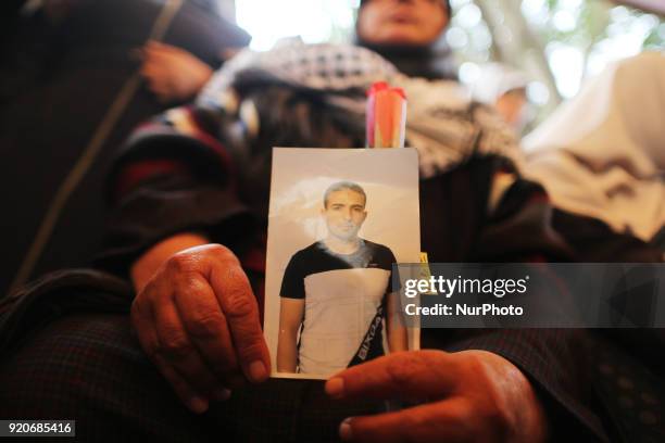 Palestinians hold poster of Ahed Tamimi during a protest to show solidarity with Palestinian prisoners held in Israeli jails, in front of Red cross...