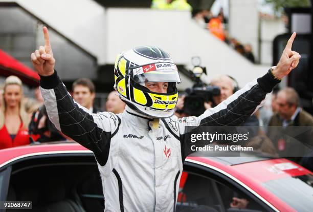 New Formula One World Champion Jenson Button of Great Britain and Brawn GP prepares to take competition winners for a drive following a Virgin...